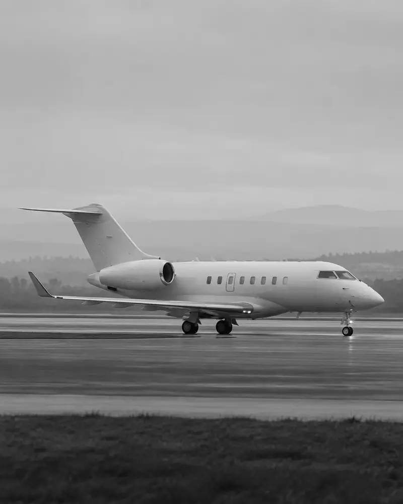 Super midsize business jet taxiing on a wet runway