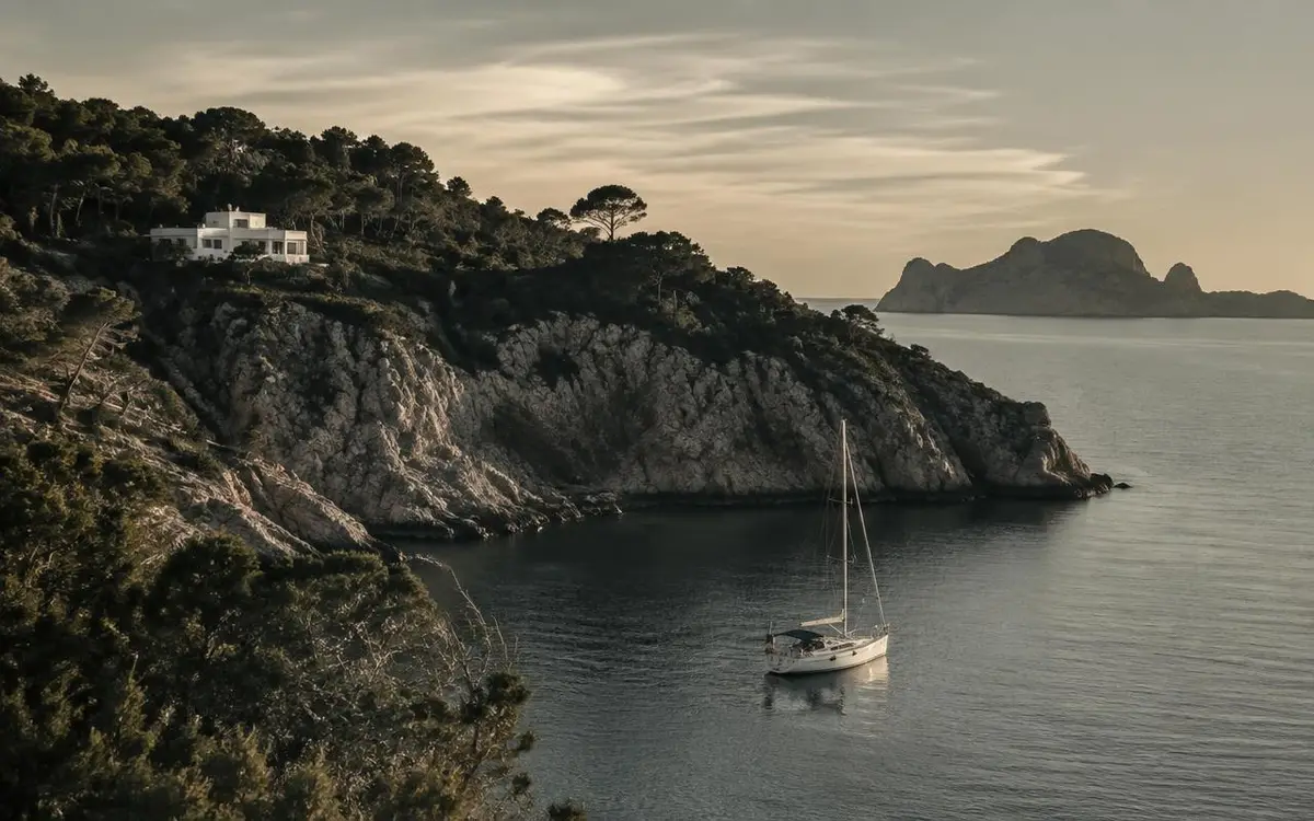 A quiet Ibiza cove beneath pine-covered cliffs